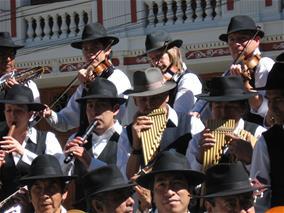 A musical performance groups plays instruments in matching black hats