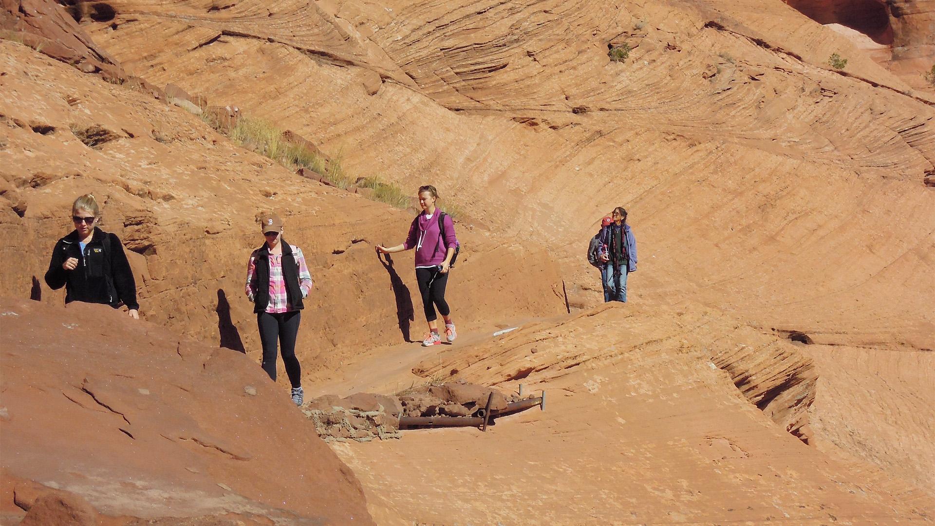 Students walk along a rock face in the western United States