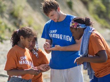 Colgate student interning with children at a beach camp