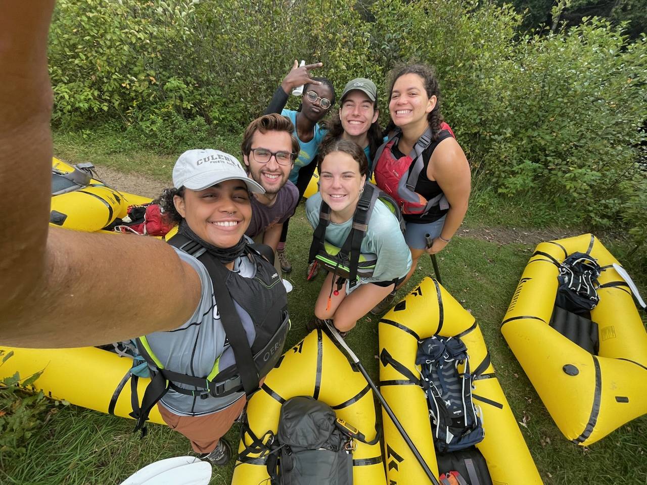 Group of Colgate students in lifejackets taking selfie with packrafts