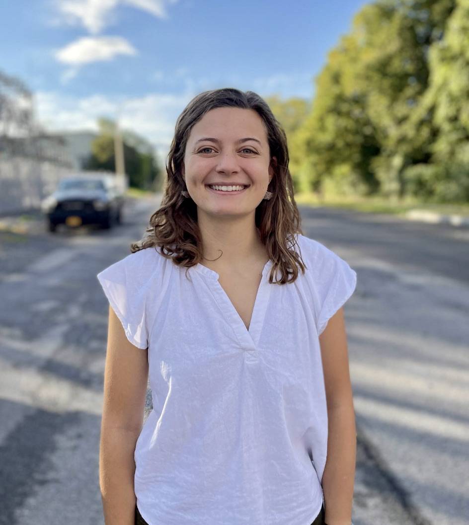 Photo of Kelsey Bennett '22 in a white shirt with a blue sky in the background.