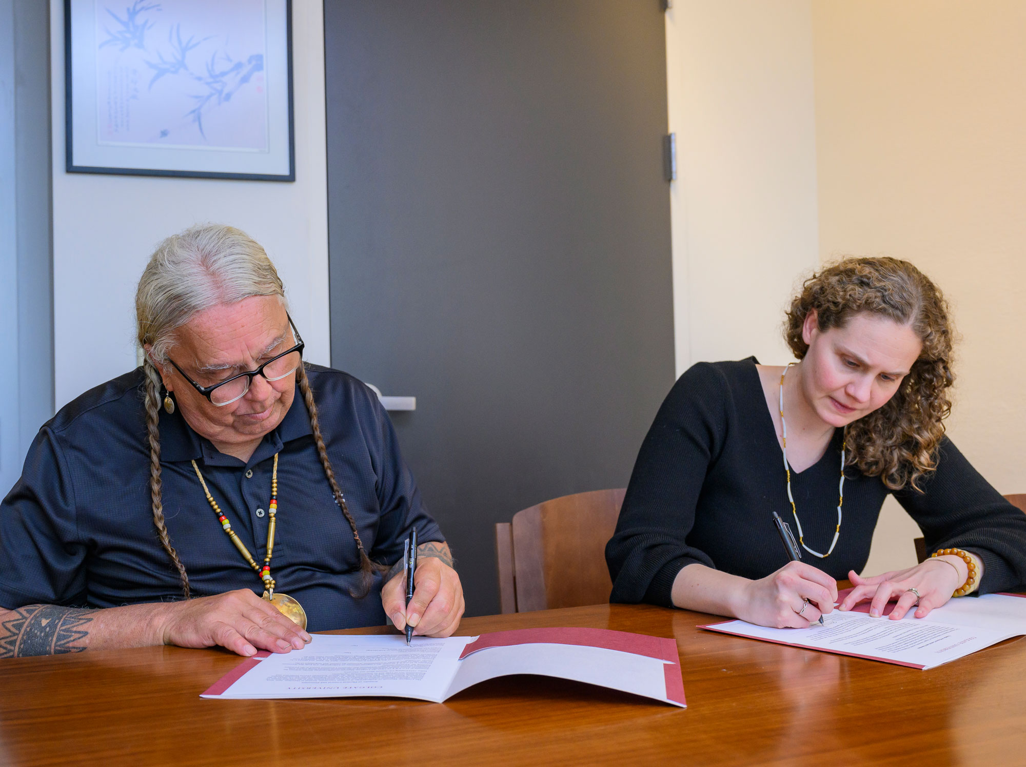 Chief Mark Tayac, Piscataway Indian Nation and Rebecca Mendelsohn, Co-Director of Colgate University Museums and Curator of the Longyear Museum of Anthropology sign the repatriation transfer paperwork