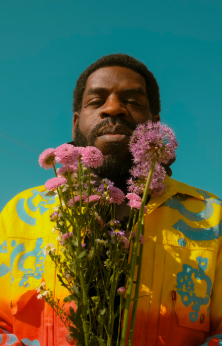 Hanif Abdurraqib holds flowers in headshot photo