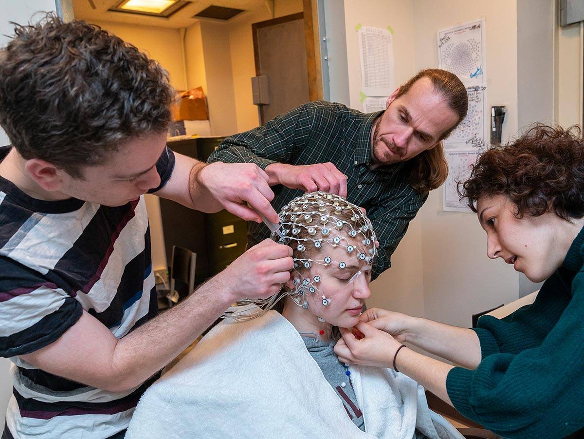 Professor Bruce Hansen and student researchers prepare a research subject in the EEG laboratory