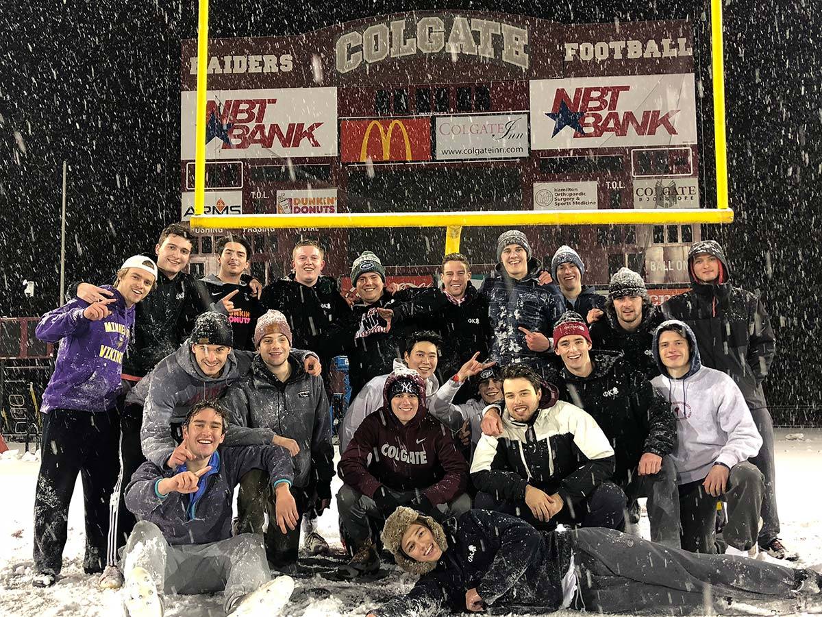 The intramural flag football champions pose for a team photo in the snow at Andy Kerr Stadium