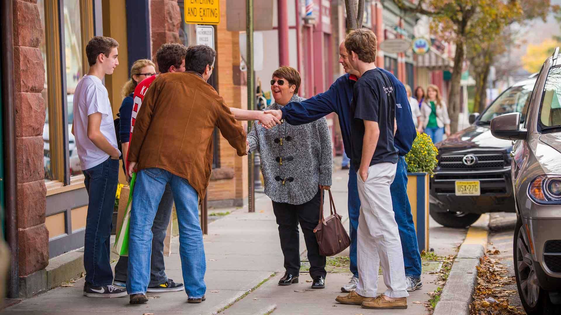 Two families greet one another and shake hands in downtown Hamilton