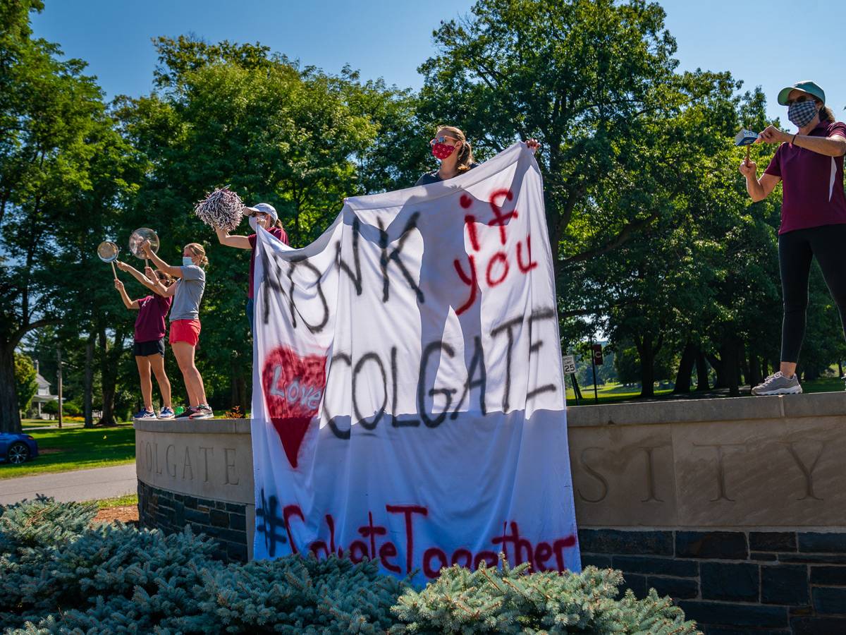 Staff members banging pots and pans on the Colgate sign.