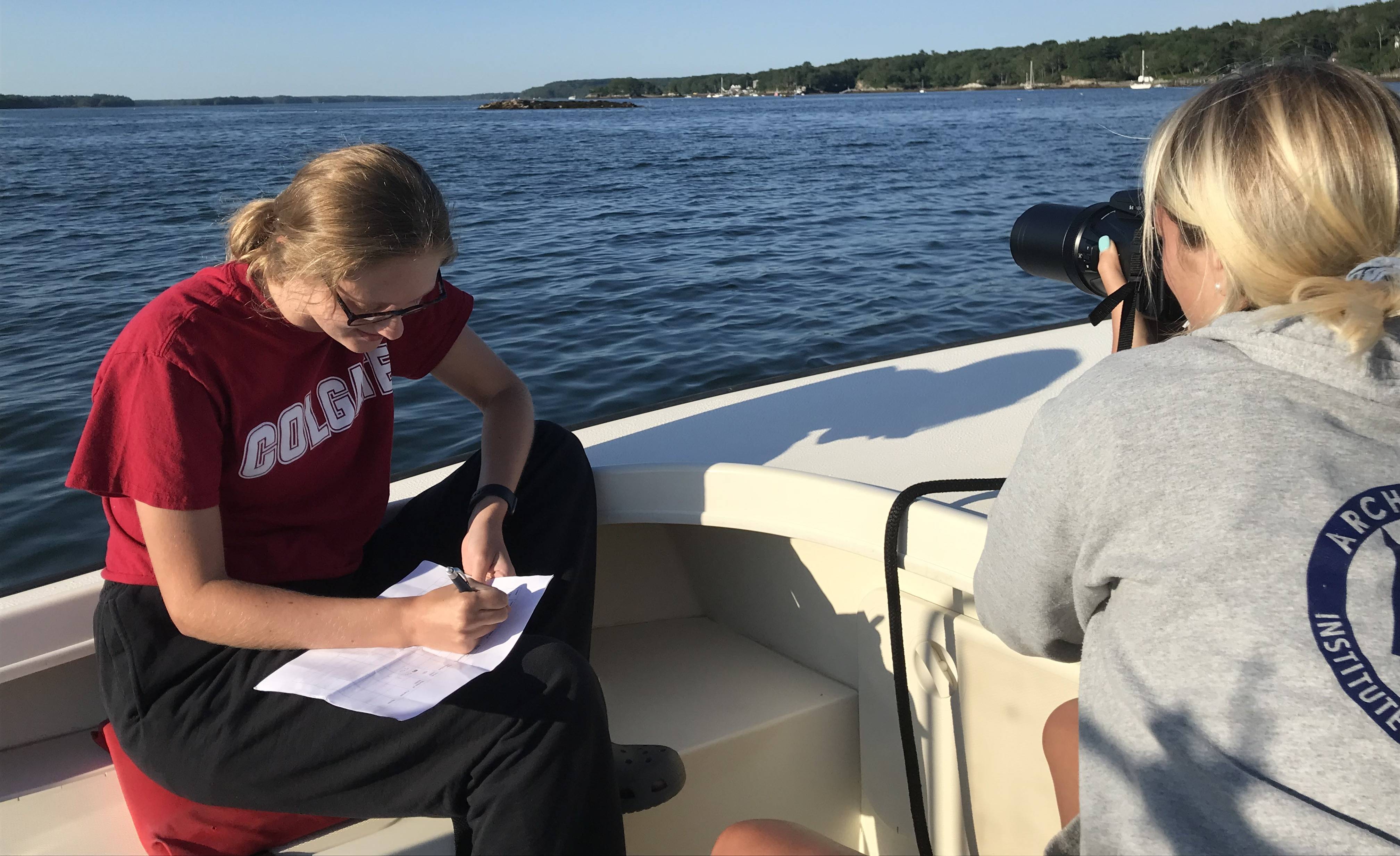 Hailey and Lauren Horstmyer ’22 taking pictures of harbor seals and recording data in Casco Bay, Maine