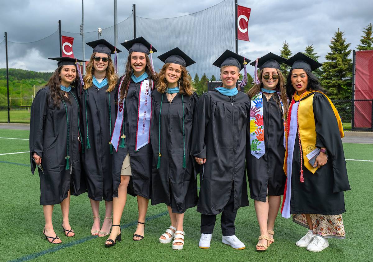 Group of 2024 Colgate graduates pose as someone takes a picture