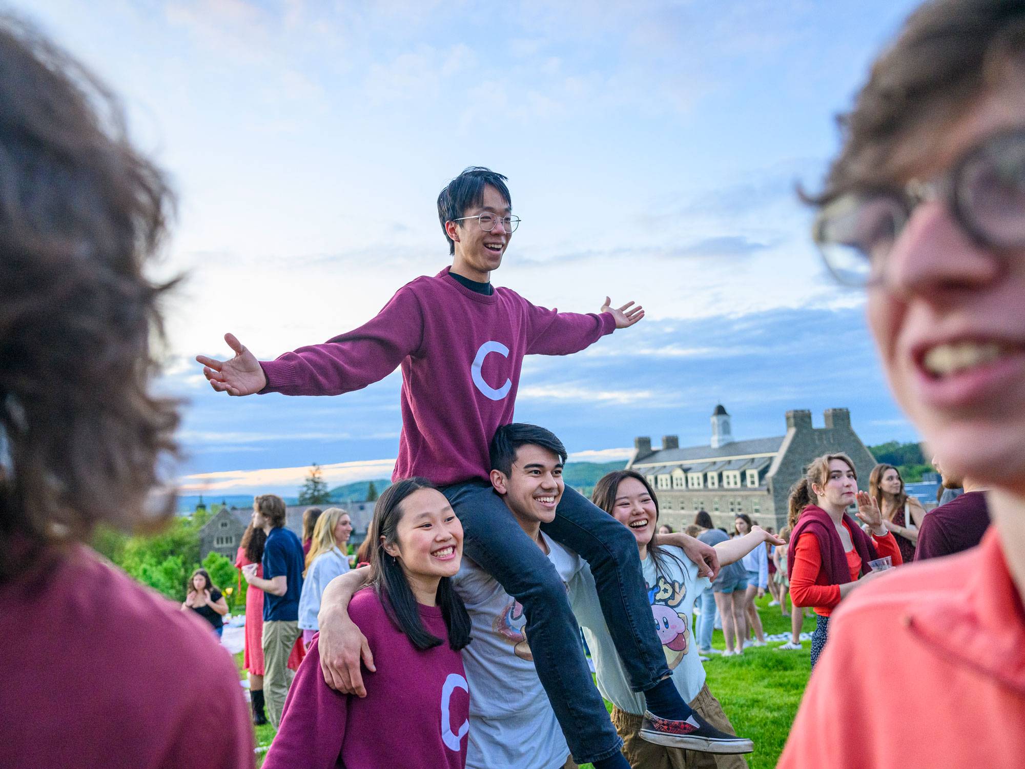 Students carrying classmate on shoulders