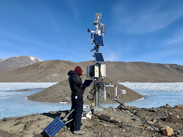 A McMurdo Dry Valleys Long Term Ecological Research project technician services the Lake Hoare weather station used in this study. Photo credit: Hilary Dugan