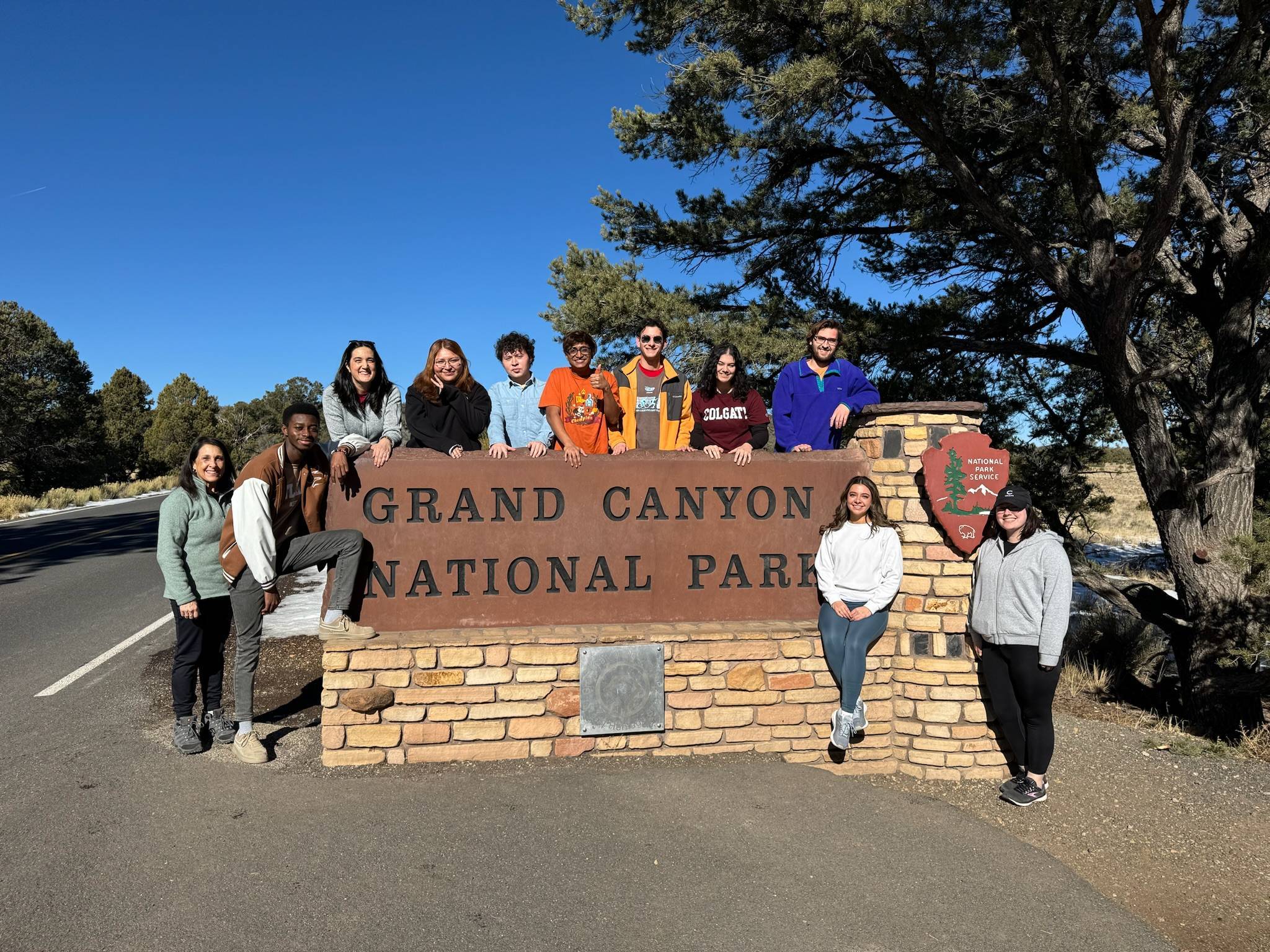 Students pose for a photo at the Grand Canyon National Park sign