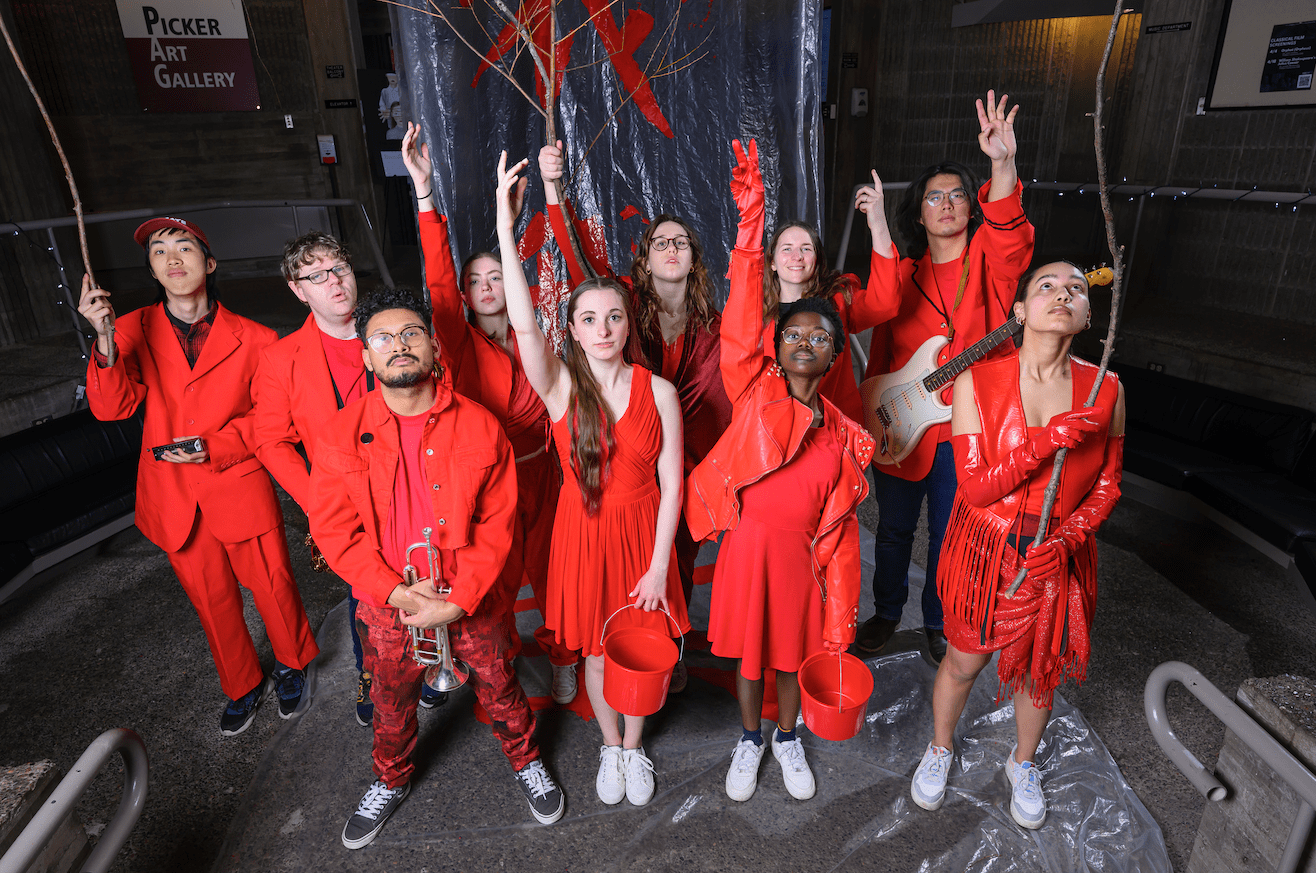 Students of the Spring Dance Concert: DIS/UNITY performance posing in red costumes.