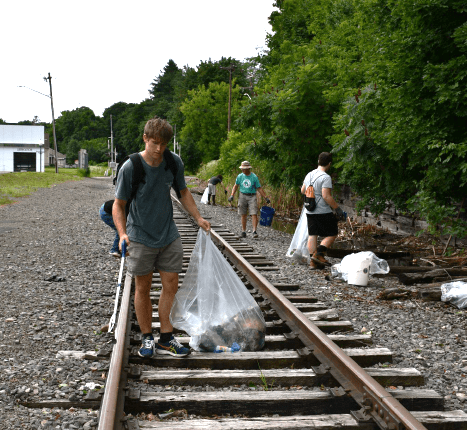 Ayden Simpson '25 picking up trash along the future Chenango Heritage Rail Trail.