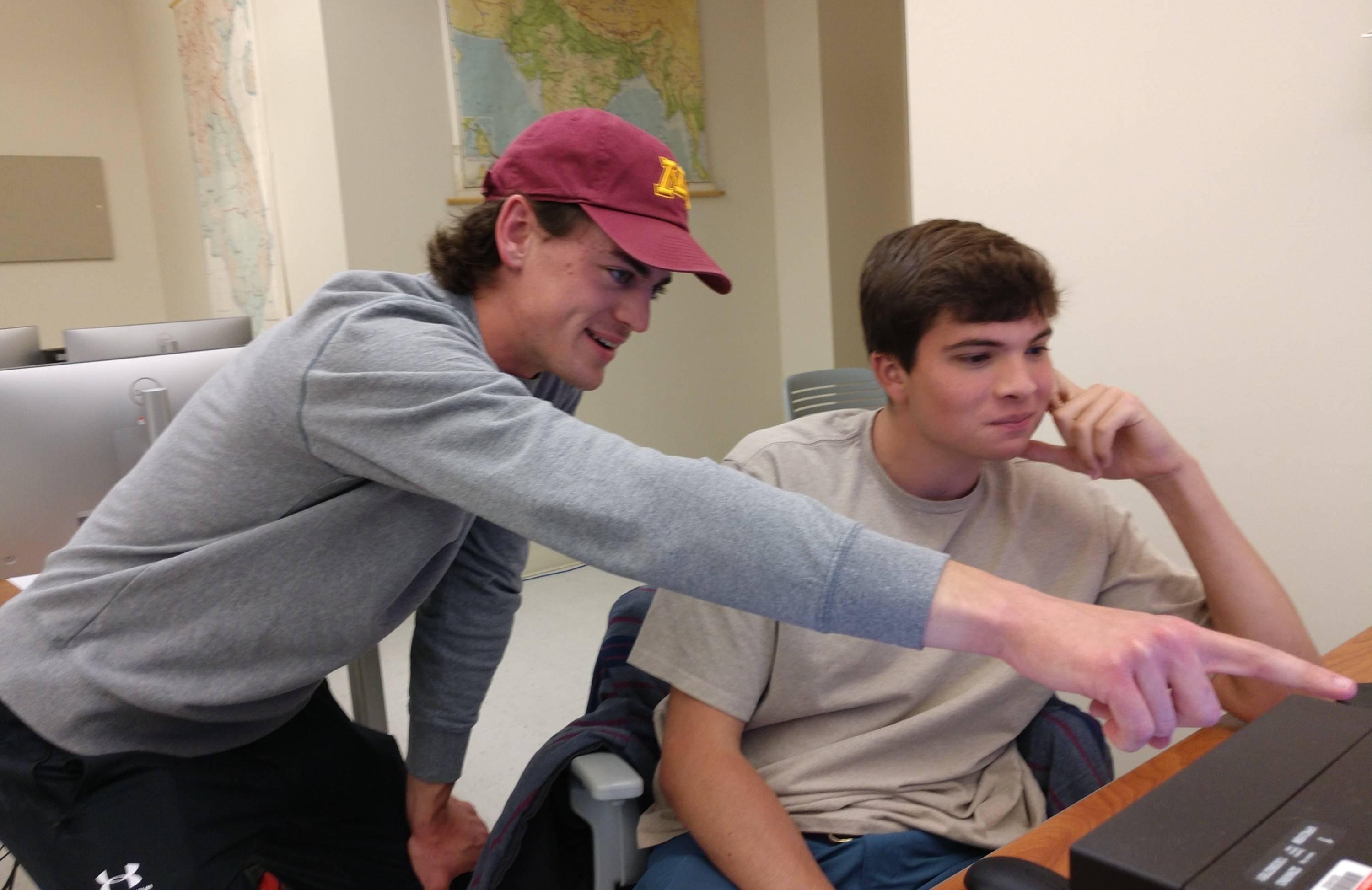 Declan Huddleston '26 pointing out something enlightening to Cal Tortolani '26 on a computer screen.