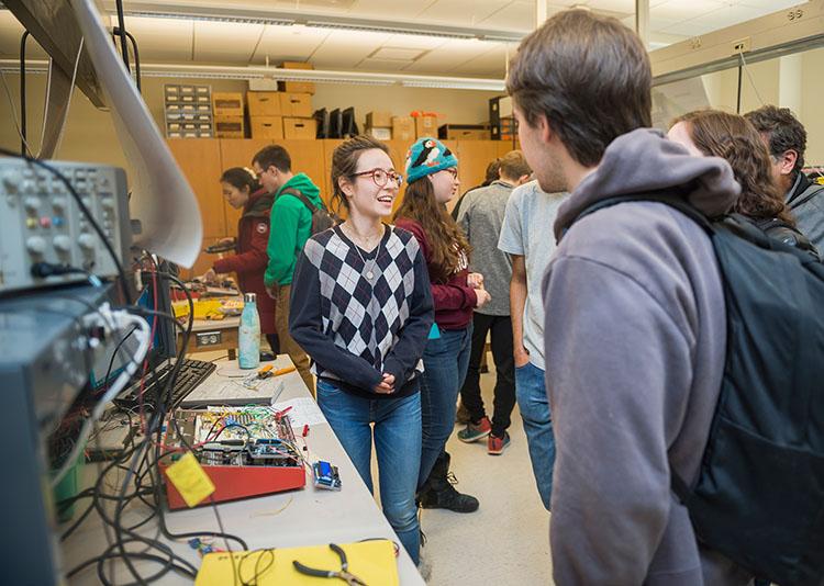 Woman presents science project to group of students