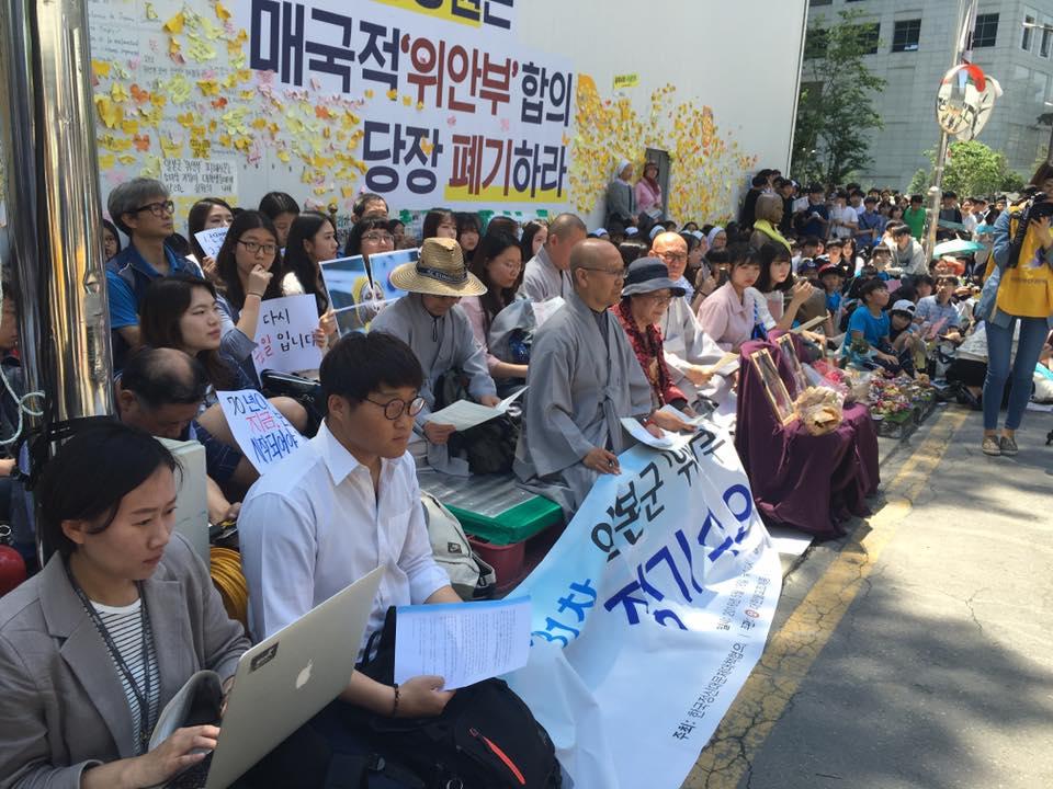 A photo of youth activists gathered around a statue in Seoul, South Korea