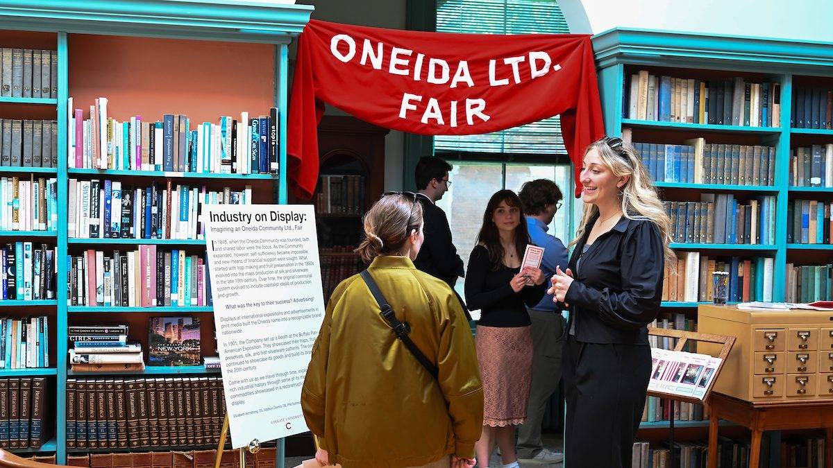 Elizabeth Armstrong ’25 speaks with guests about “Industry on Display,” an exhibit exploring the utopian community’s transition to silverware manufacturing during the opening of “Fresh Perspectives on the Oneida Community Mansion House” April 30.