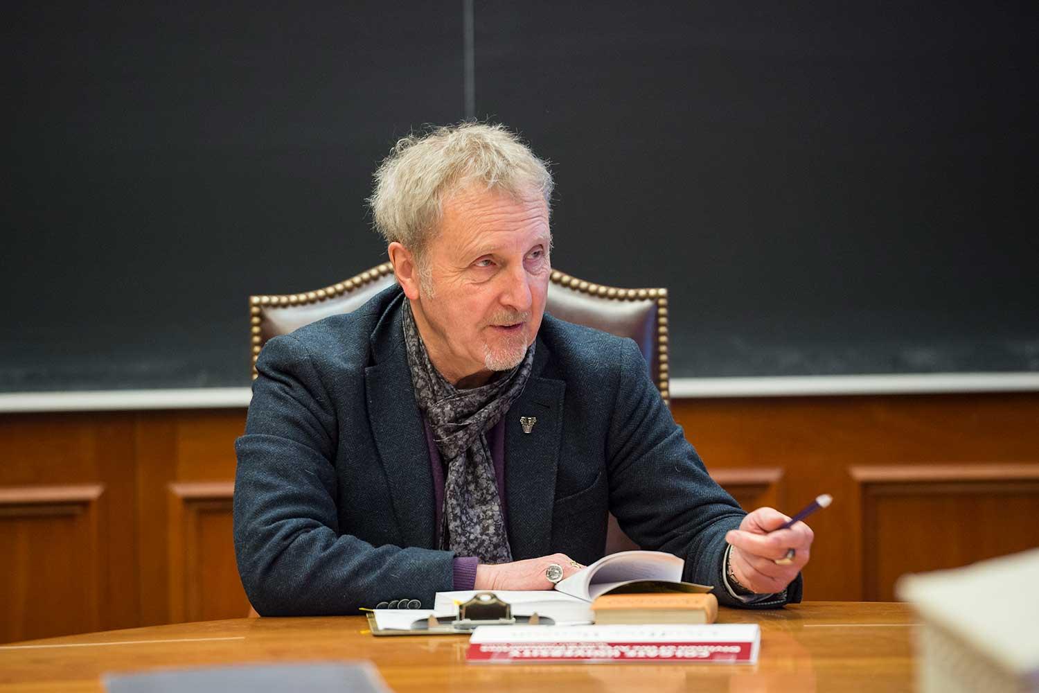 Robert Garland, Roy D. and Margaret Wooster Professor of the Classics, teaches while sitting at table