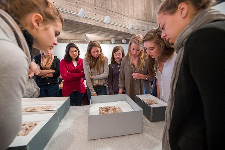 Students examine Egyptian artifacts as part of class.